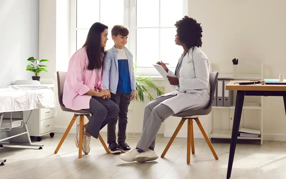 Female doctor talking to a mother and child - Smart Health Benefits Association